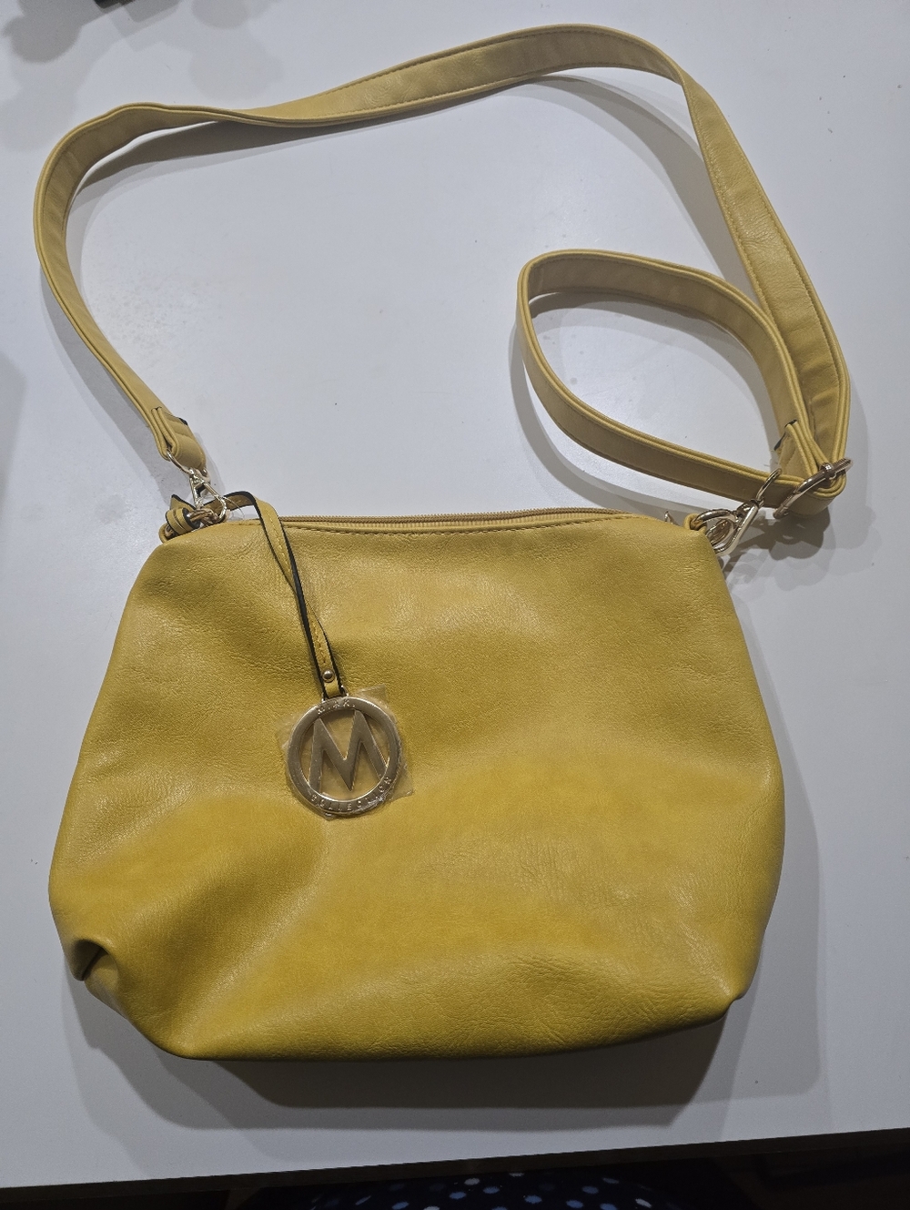 MIAK Collection by Mia K. Medina vegan leather crossbody bag features gold-tone